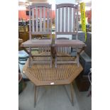 A teak garden table and four folding chairs