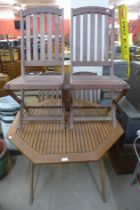 A teak garden table and four folding chairs