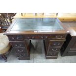 A mahogany and green leather topped pedestal desk