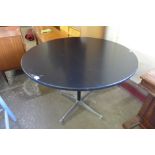 An Eames style circular black and steel based kitchen table