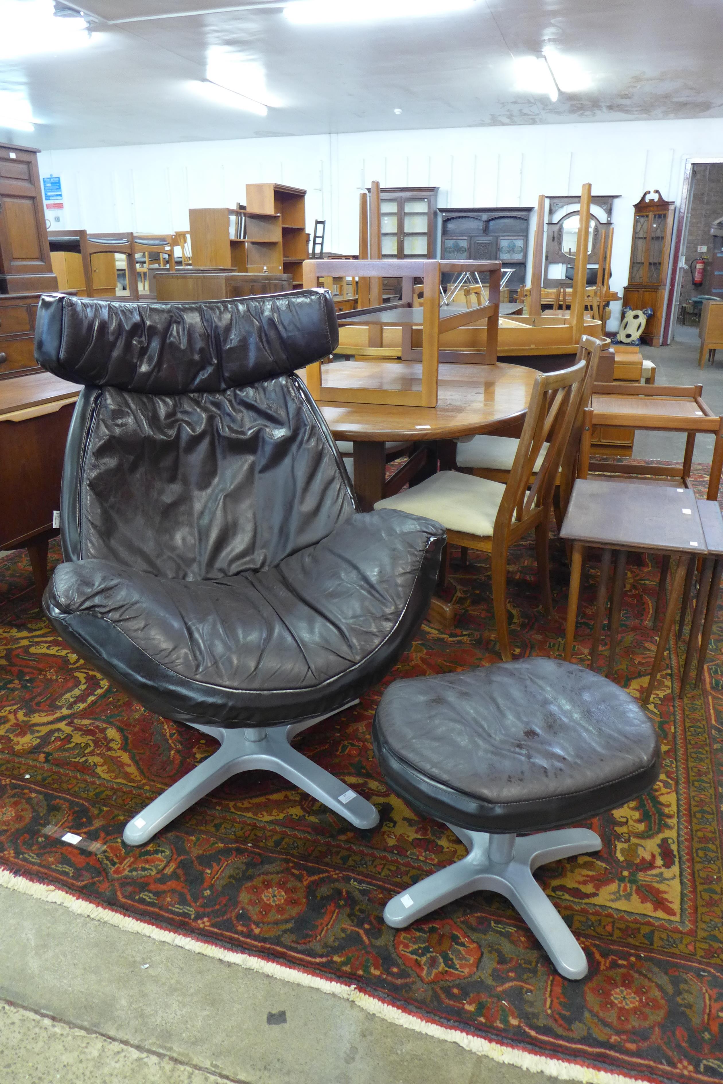 A vintage leather revolving lounge chair and stool