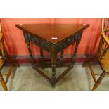 A 17th Century style carved oak fold over corner table