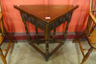 A 17th Century style carved oak fold over corner table