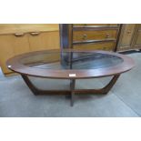 An oval teak and glass coffee table