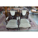 A pair of Edward VII carved mahogany and fabric upholstered open armchairs