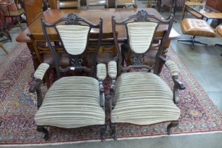 A pair of Edward VII carved mahogany and fabric upholstered open armchairs