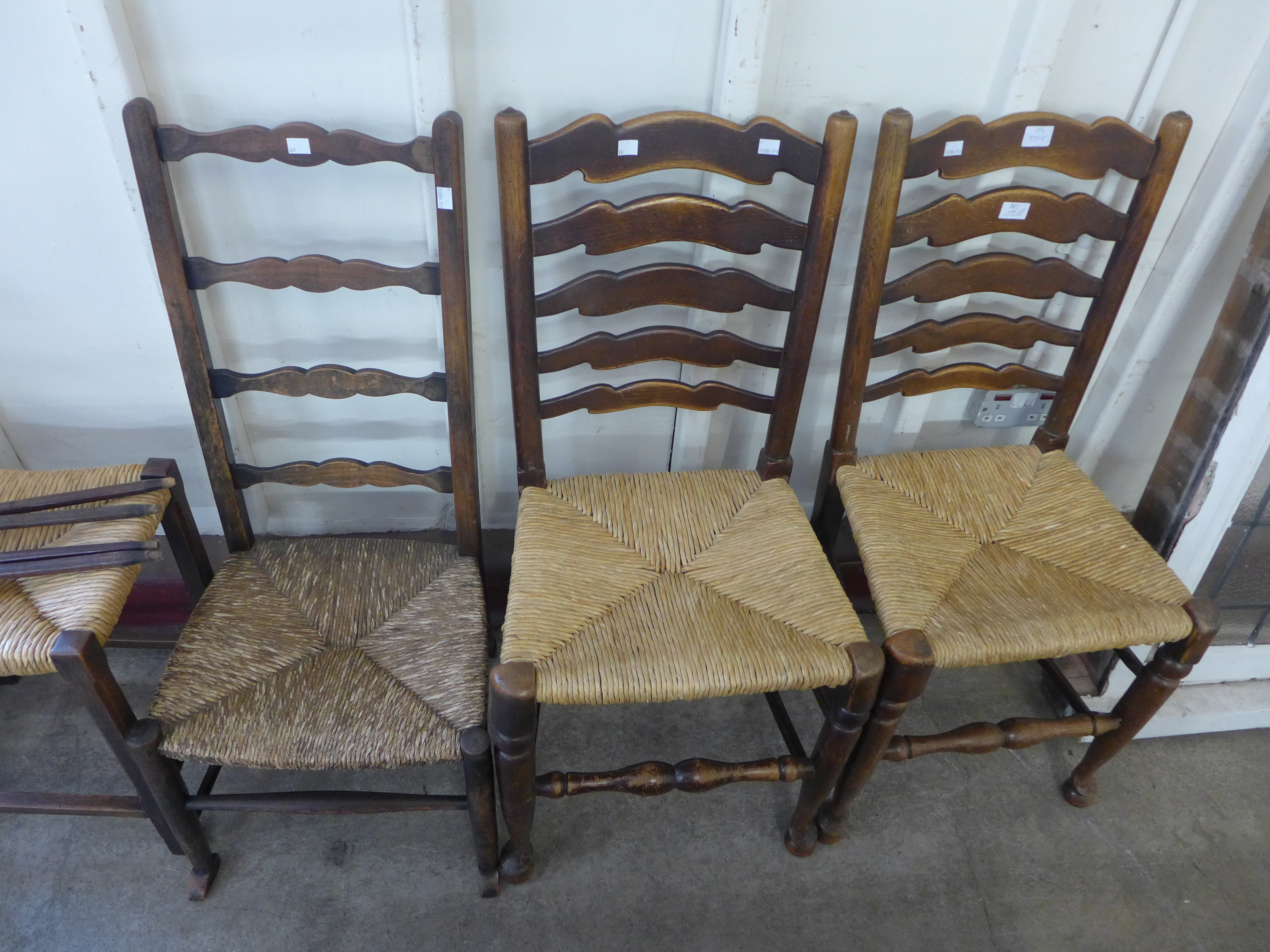 Two Arts and Crafts beech chairs (one a/f), a stool and a pair of elm rush seated ladderback chairs