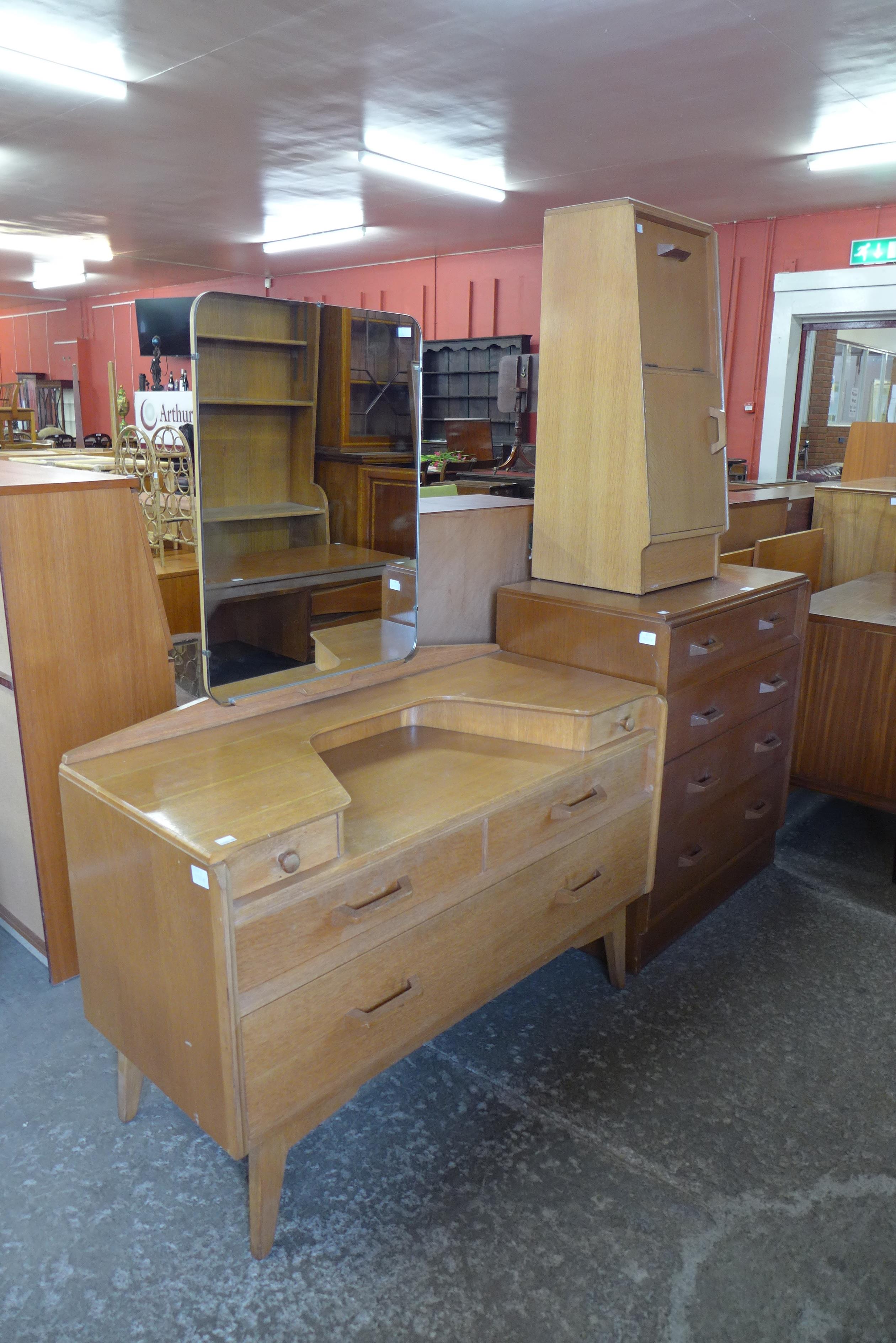 A G-Plan Brandon oak three piece bedroom suite, comprising chest of drawers, dressing table and a