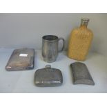 A large plated hip flask, two others, a water bottle and a pewter mug with dragon decoration, mug