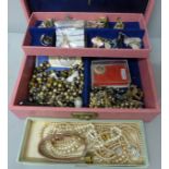 A pink jewellery box of costume jewellery including 2.3g of 9ct gold (cross, brooch and pendant)