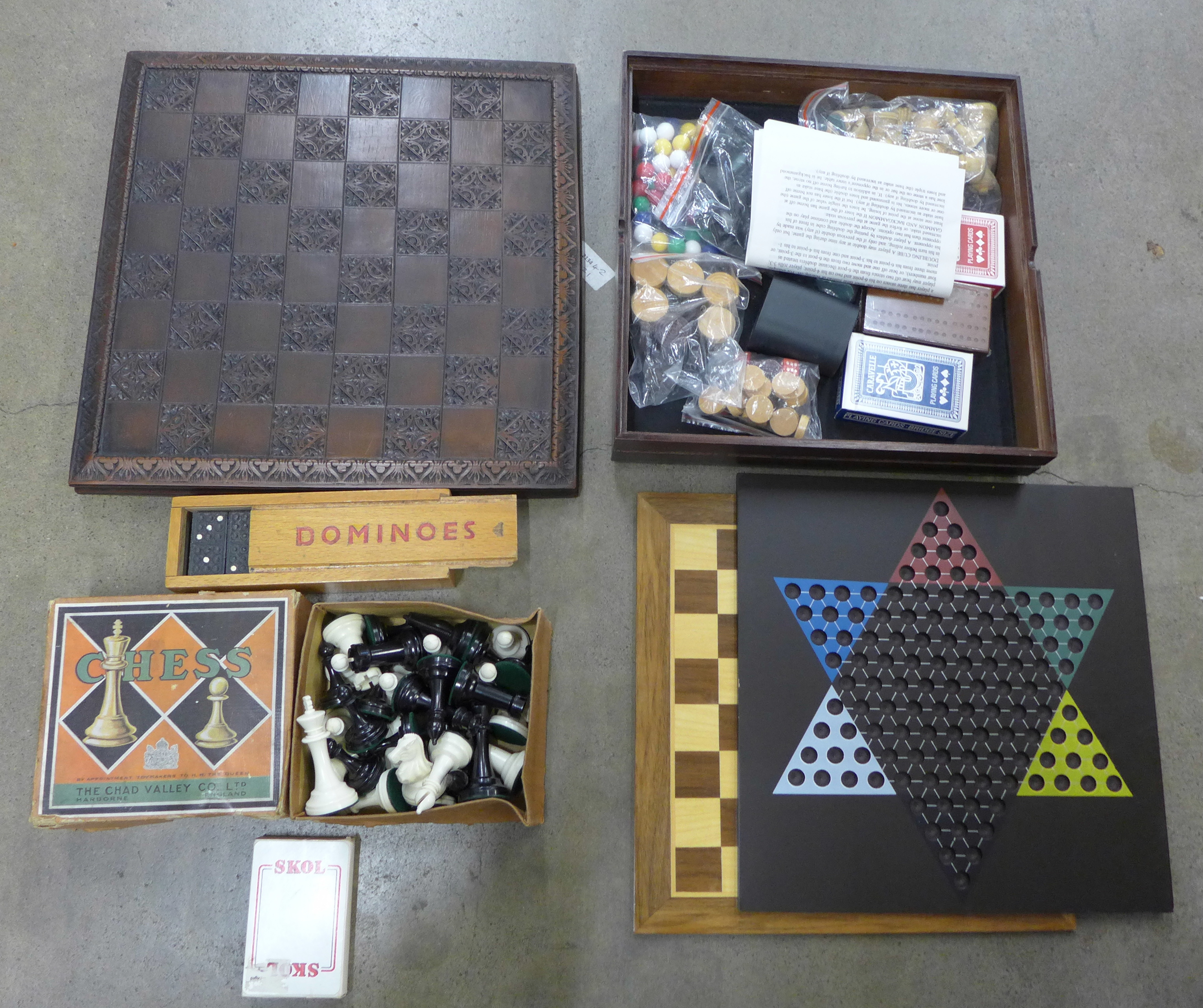 A collection of board games including chess sets, dominoes and playing cards