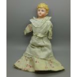 A circa 1900 doll with bisque head and soft body, lacking arms, 24cm