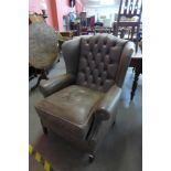 A light brown leather Chesterfield wingback armchair