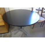 An Eames style circular black and steel based kitchen table