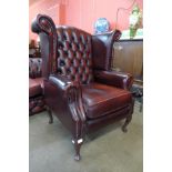 An oxblood red leather Thomas LLoyd Chesterfield wingback armchair