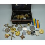 A pair of WWI medals to Gnr. Jervis R.A., and a collection of military badges, etc.