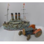 A model battleship made from Smiths Potato Crisps tins and a tin-plate model clockwork tractor, ship