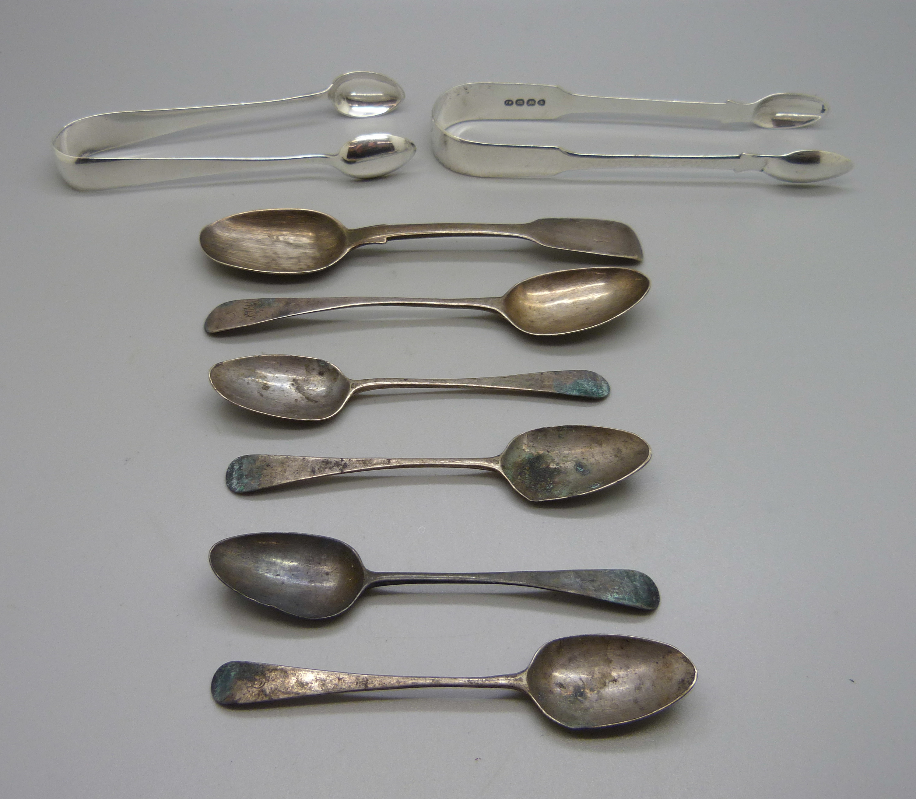 Two pairs of silver sugar bows and six silver spoons, 133g