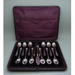 A set of twelve silver spoons, with sugar bows and butter knife, 251g, associated case