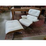 A Charles & Ray Eames style simulated rosewood and cream leather revolving lounge chair and stool