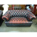 An oxblood red leather Chesterfield settee