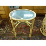A circular bamboo and glass topped occasional table