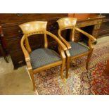 A pair of Arts and Crafts style mahogany elbow chairs