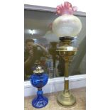 Two oil lamps, one blue glass and one brass with a glass shade **PLEASE NOTE THIS LOT IS NOT