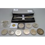 A collection of commemorative coins and a Cross pen