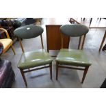 A pair of teak and green leather chairs