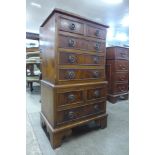 A small yew chest on chest of drawers