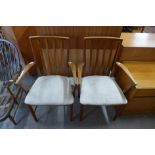 A pair of teak elbow chairs