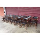 A set of twenty two early/mid 20th Century American walnut and black vinyl Windsor style chairs,