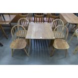 An Ercol Blonde elm and beech drop leaf table and four Windsor chairs