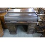 An early 20th Century oak tambour roll top desk