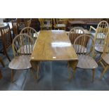 An Ercol Blonde elm and beech drop leaf table and four Windsor chairs