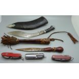 A collection of three pocket knives, a kukri and one other knife