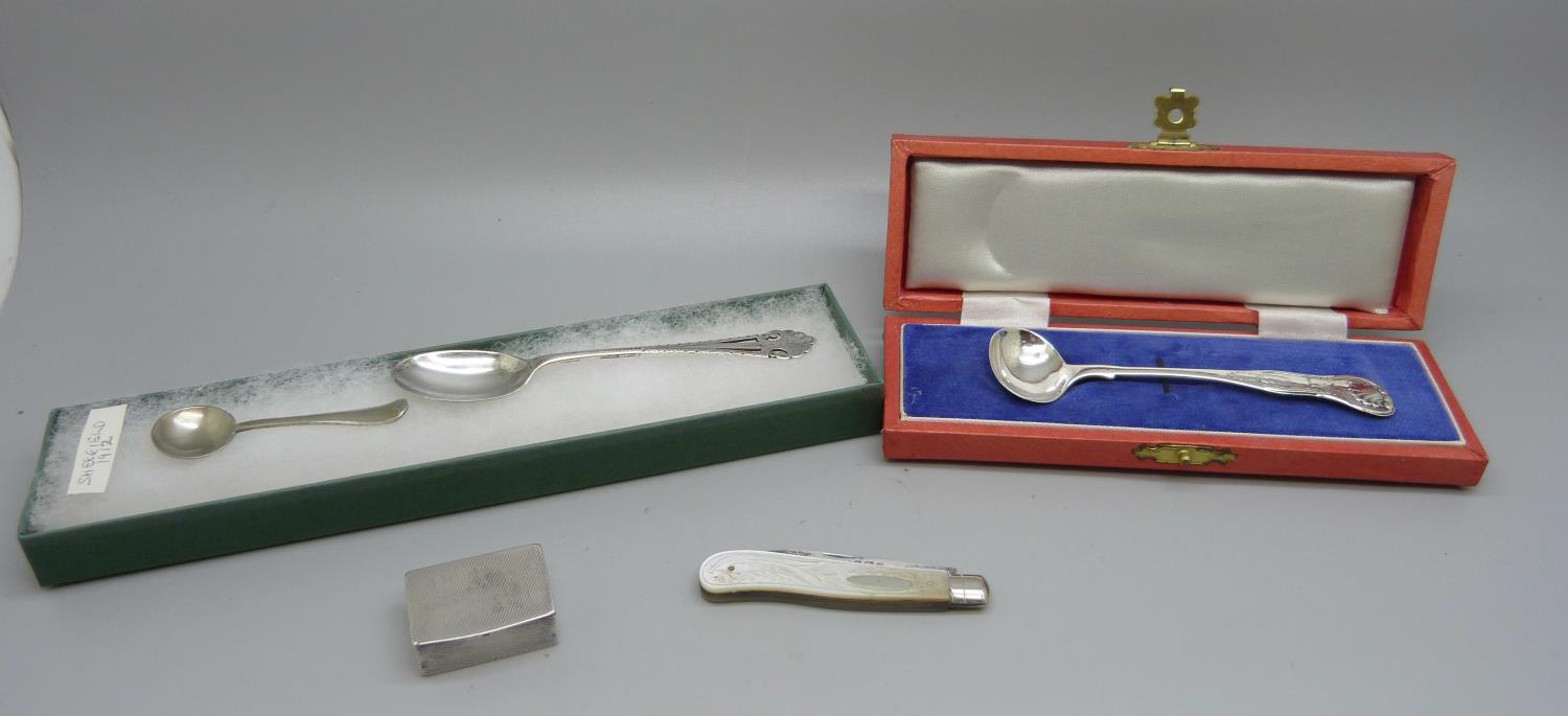 A silver pill box, two silver spoons, one cased, a Nevada silver condiment spoon and a silver and