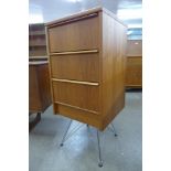 A teak chest of drawers on chrome stand