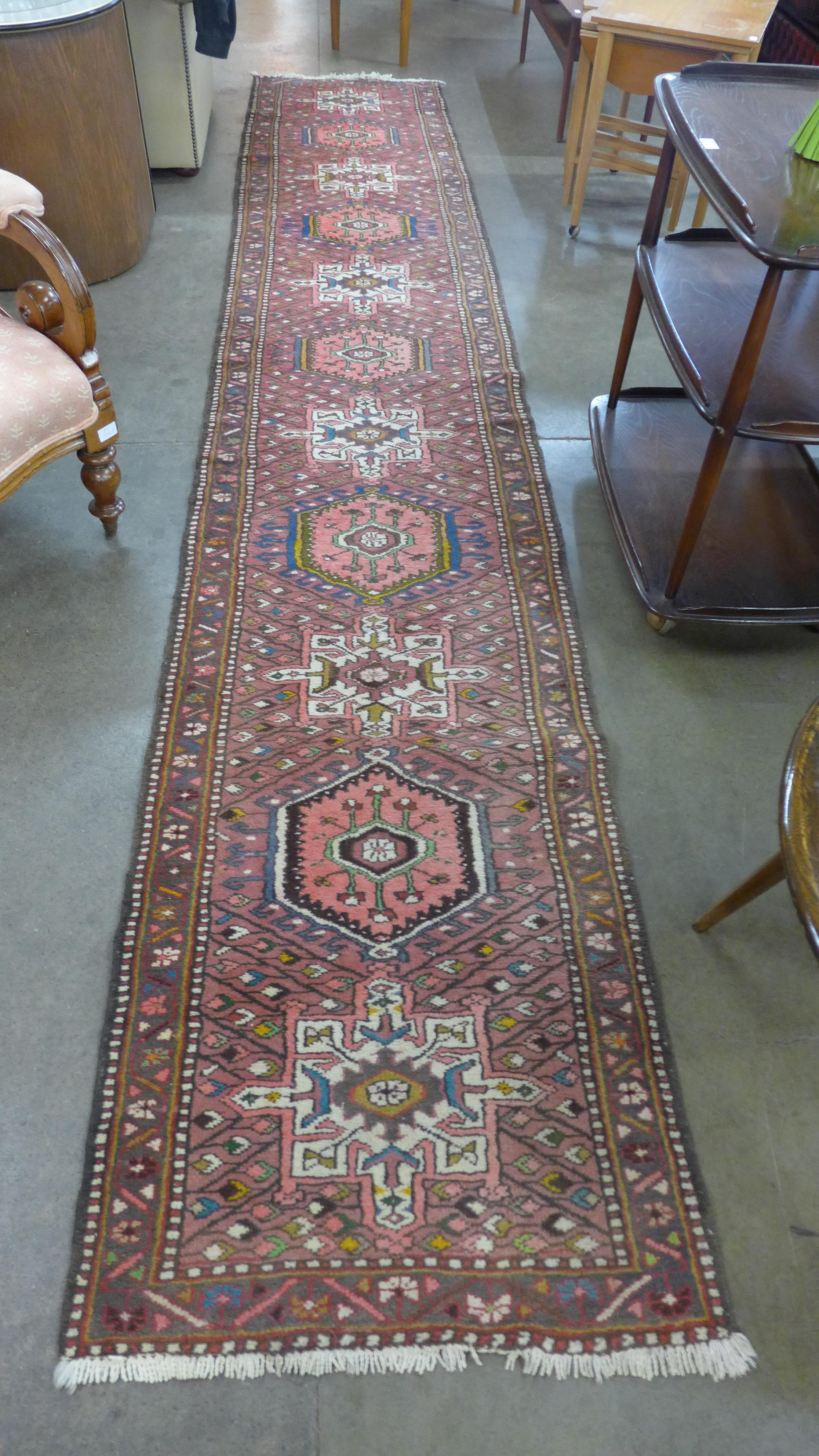 A Persian salmon pink ground runner rug