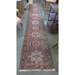 A Persian salmon pink ground runner rug