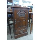 An Edward VII carved walnut music cabinet