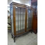 A mahogany serpentine display cabinet