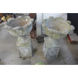 A pair of concrete garden urns on stands