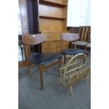 A pair of teak and black vinyl chairs and a bamboo magazine rack