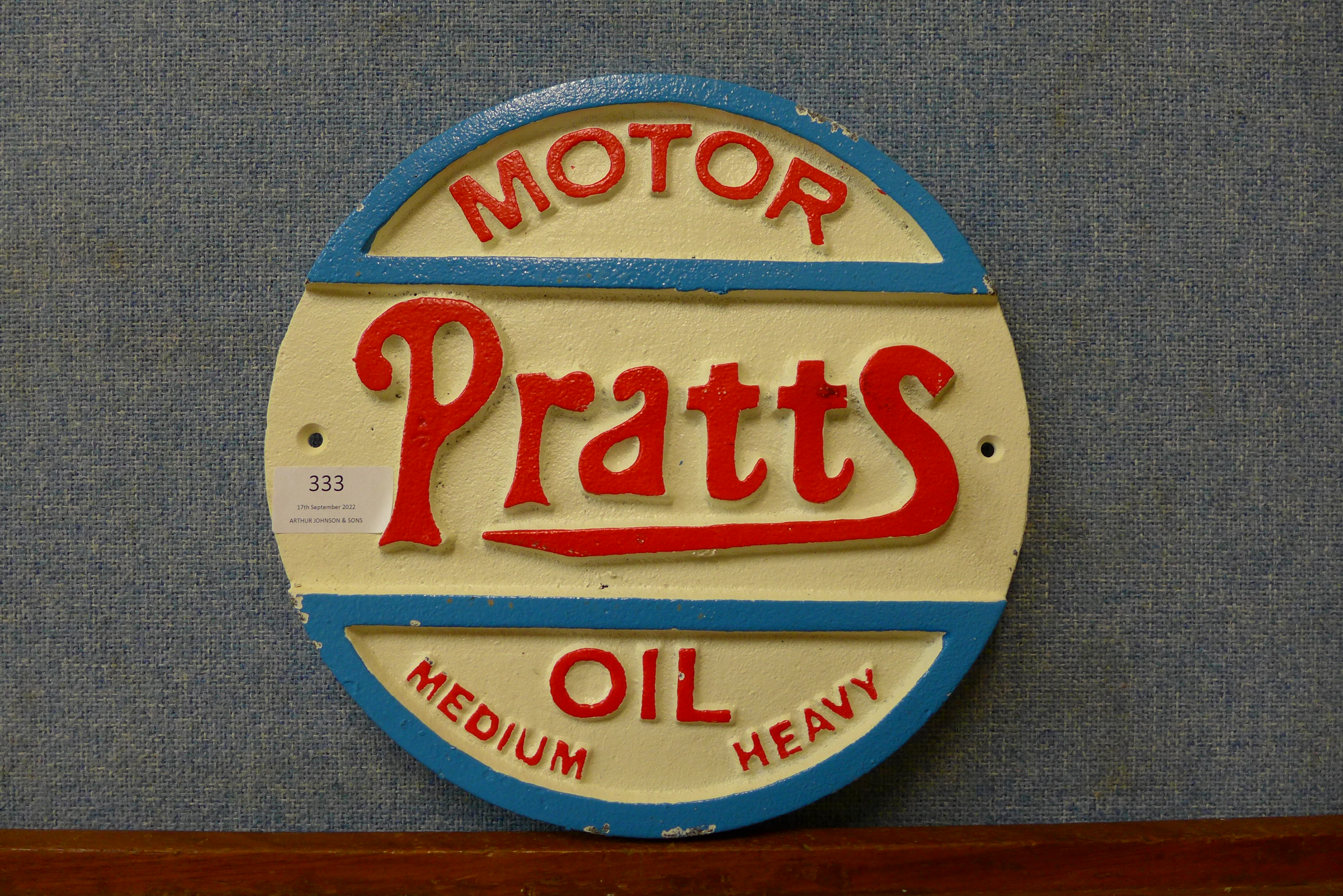 A reproduction cast iron Pratts Motor Oil advertising sign