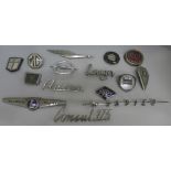 A collection of fifteen car badges including Sunbeam Rapier