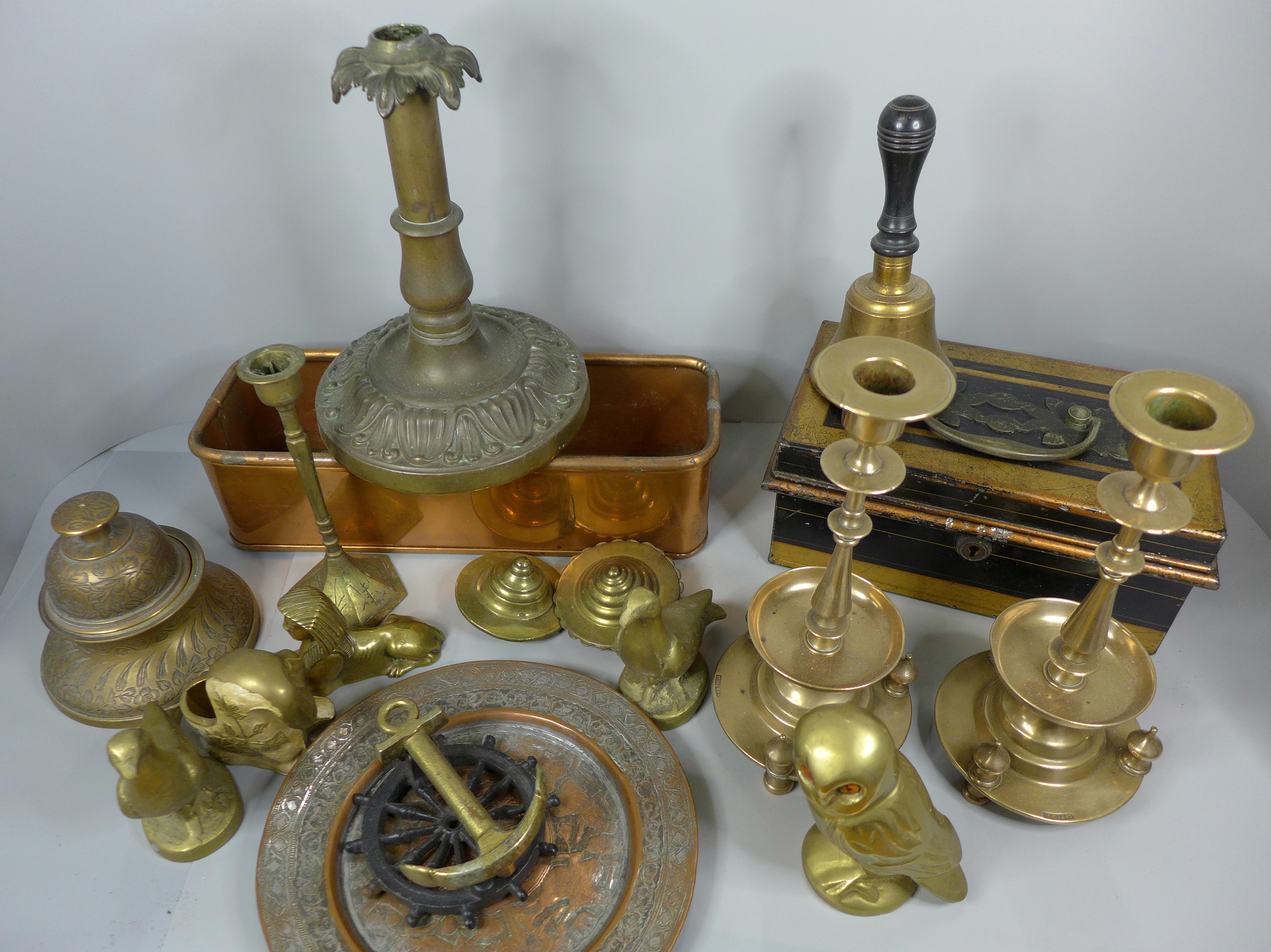 A collection of brass including candlesticks, ornaments, a bell, a copper dish, a door knocker and a