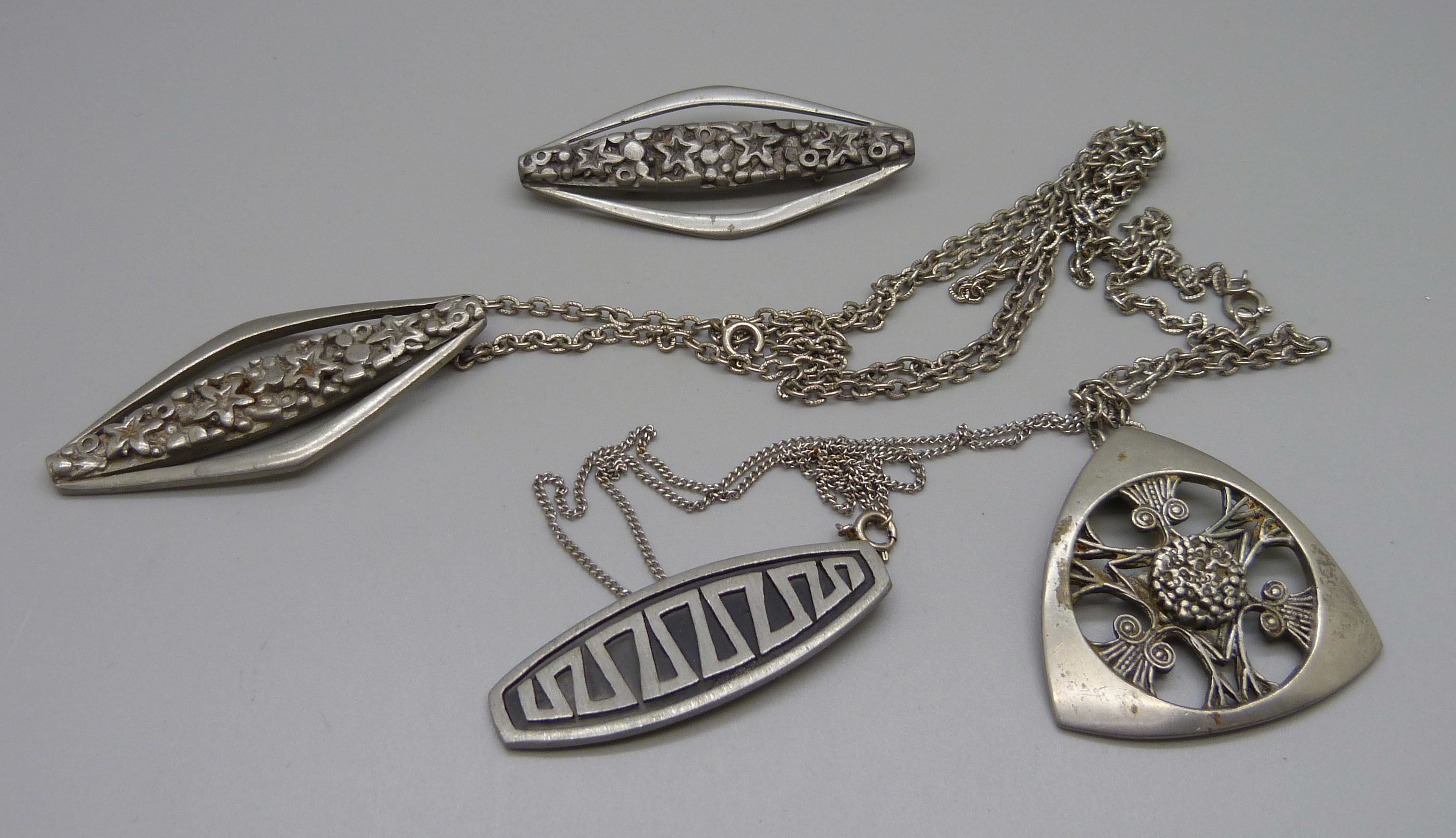 Three pewter pendants and a brooch, all marked Scotland