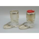 A pair of novelty silver rimmed glass match strikers in the form of boots